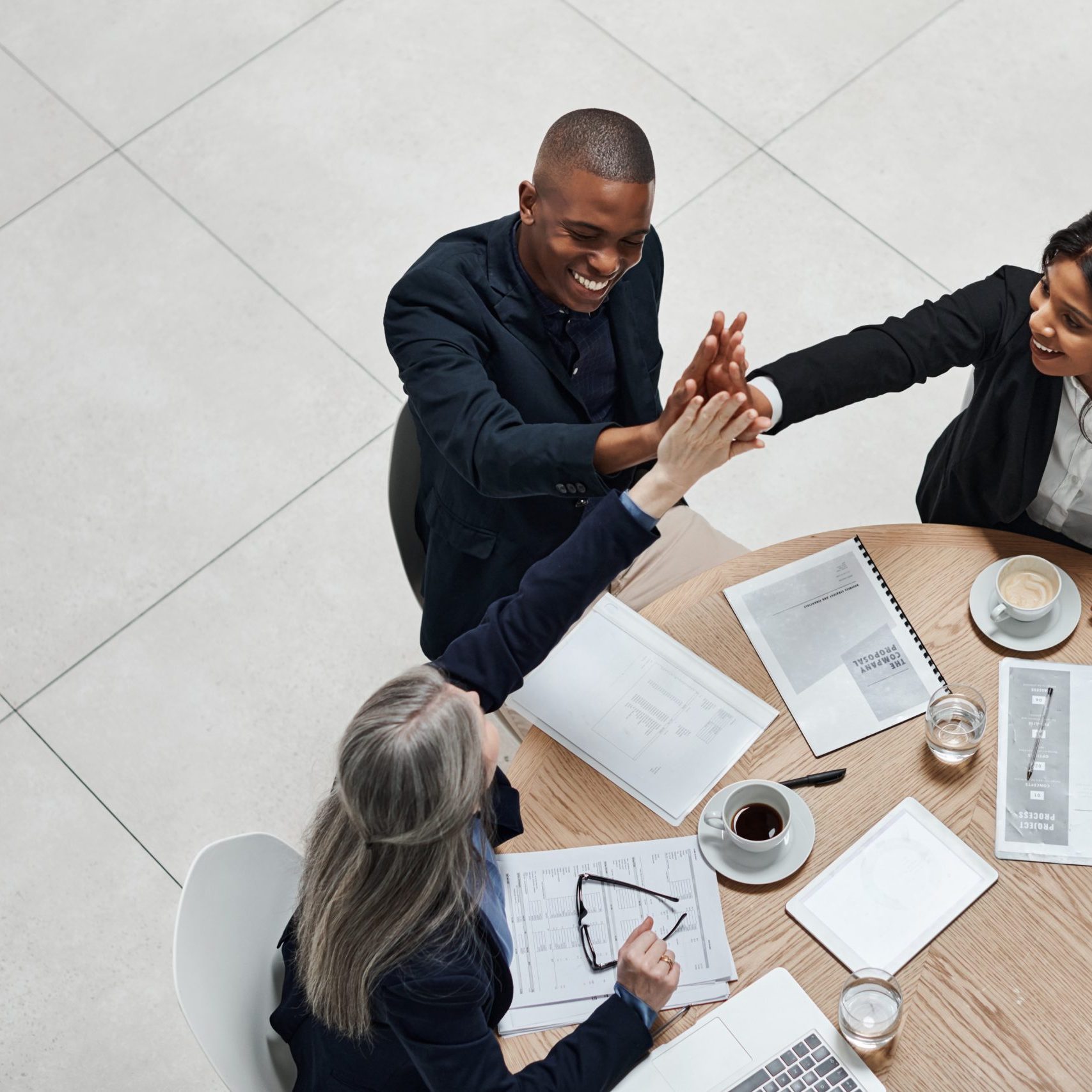 Business people, meeting and office with high five for success to celebrate company growth, feedback and positive review. Teamwork, top view and happiness for achievement, reputation and milestone